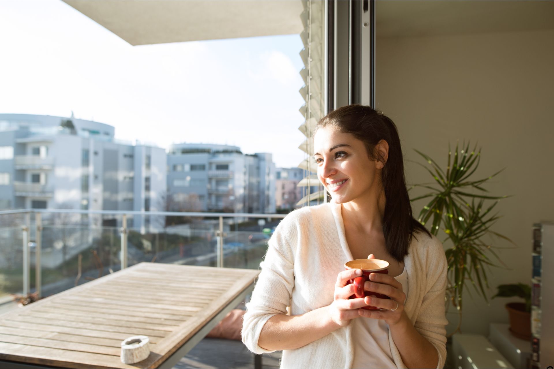 young woman drinking coffee on the terrace and listening to her intuition